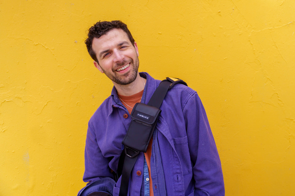 Michael Mishali hiking with a camera